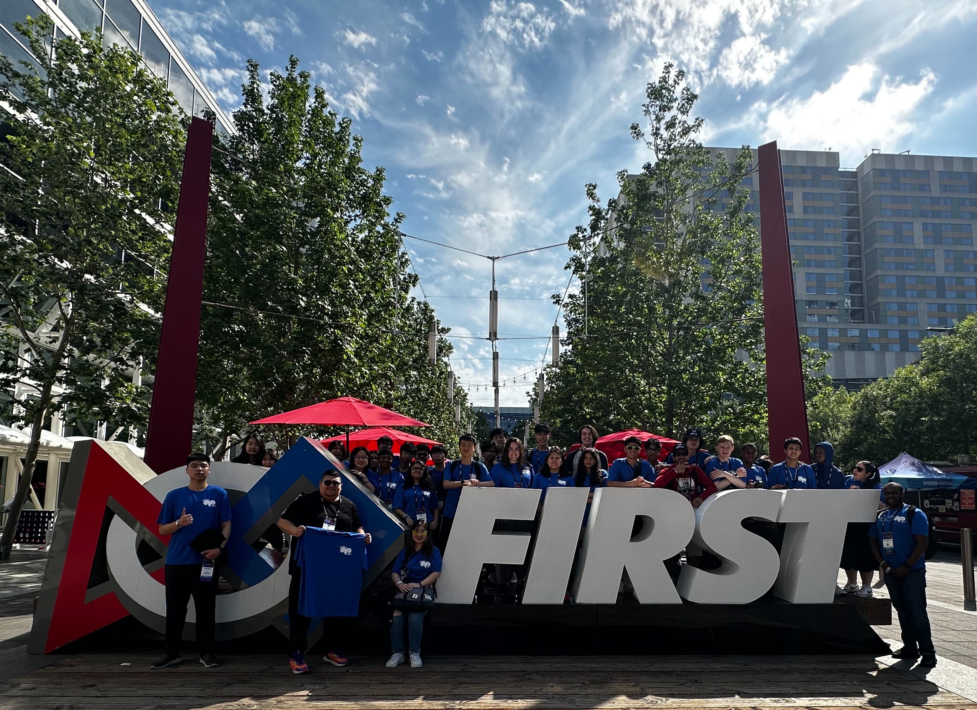 The Rambots in matching blue shirts posing behind the large FIRST sign at Championships in Texas